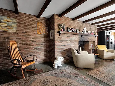 Living room with exposed beams and brick